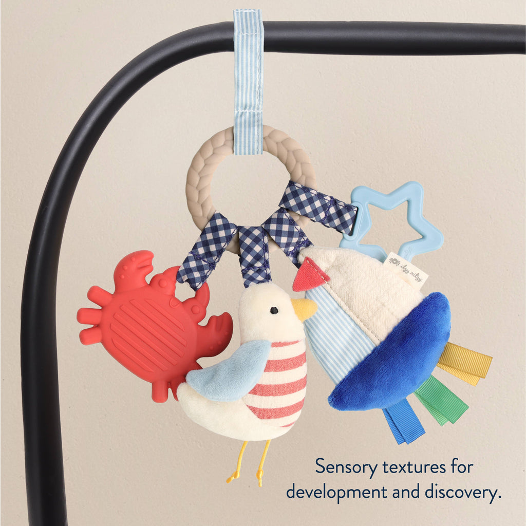 Colorful baby toy set with a crab, duck, and star shape on a blue packaging background.