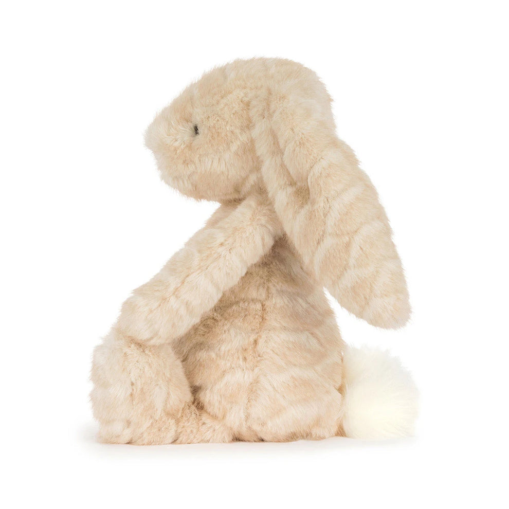A plush stuffed bunny toy in a light cream or beige color, featuring long floppy ears, a pink stitched nose, and small black bead eyes, shown against a plain white background.