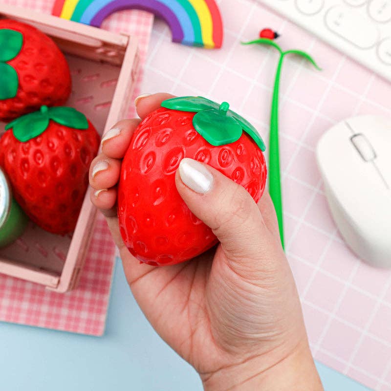 Red strawberry-shaped sensory toy with green top on a white background