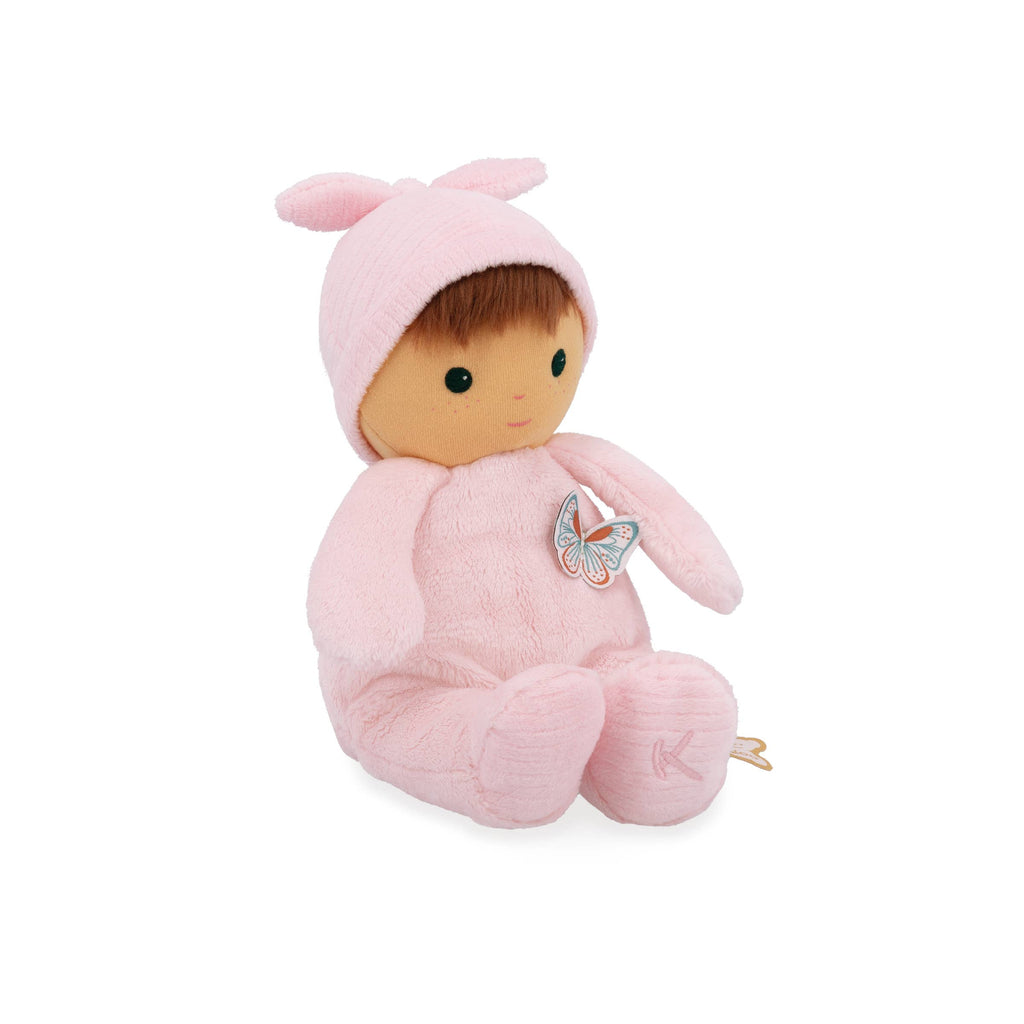 Plush baby doll in a pink outfit with butterfly design on a white background