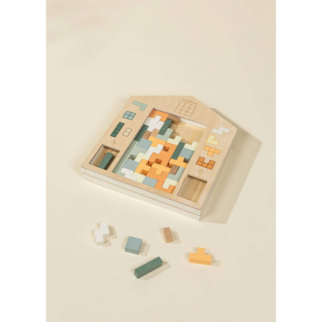 Wooden building block set with geometric shapes in a house-shaped display on a beige background
