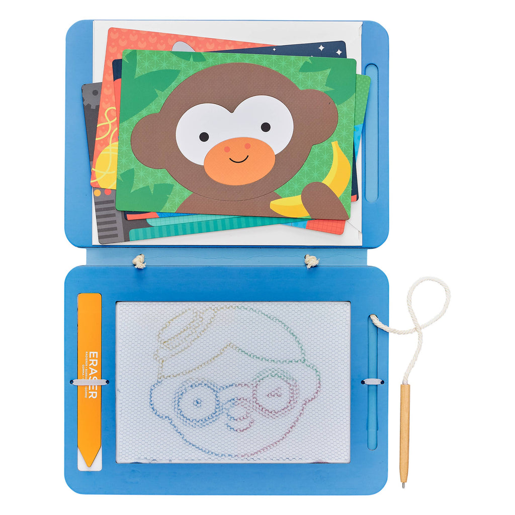 Child drawing with colorful paper cutouts of faces on a wooden table