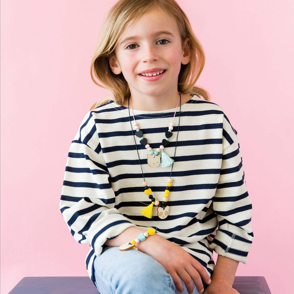 Wooden jewellery craft kit packaging with colorful polka dot design on a beige background