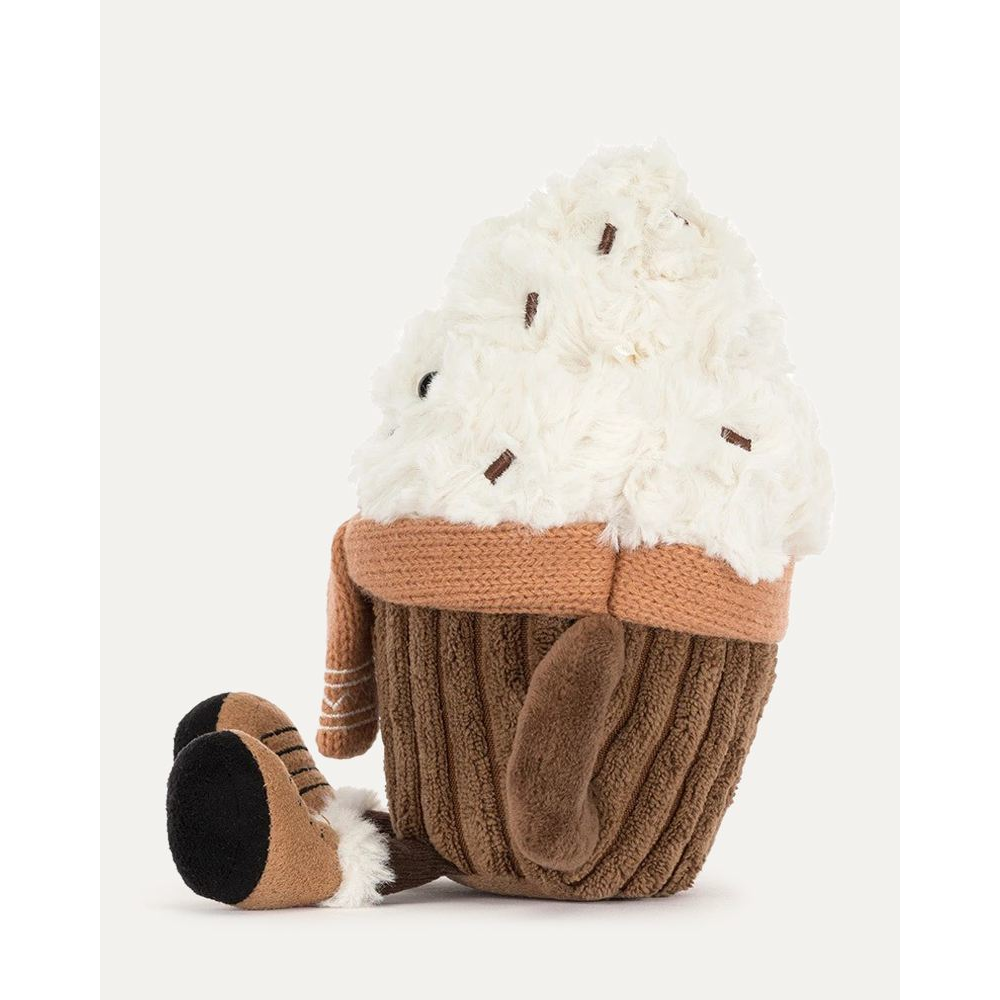 A plush cupcake toy with fluffy white frosting, a brown corduroy wrapper, a tan knit scarf, and black-and-tan feet, photographed on a clean light gray background.