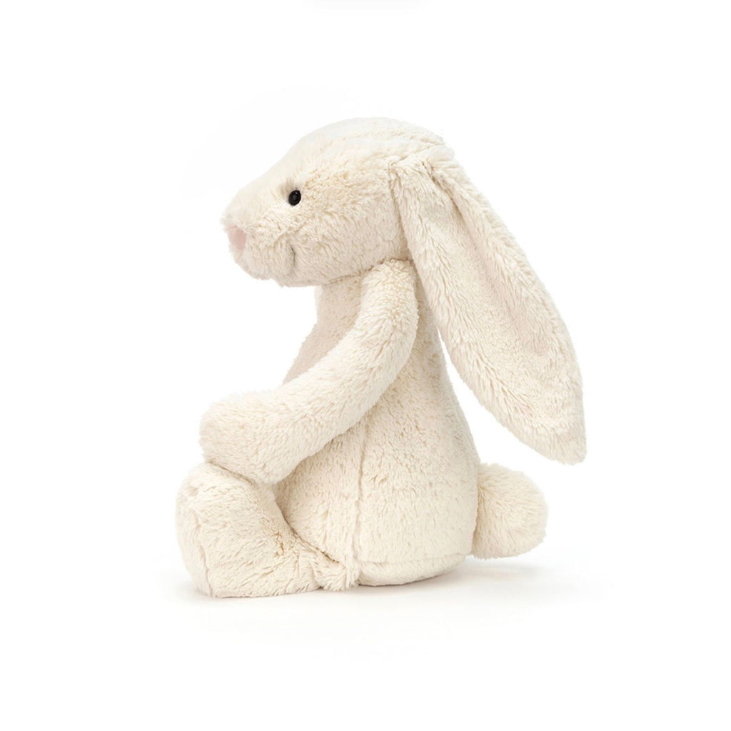 A cream-colored plush bunny stuffed animal with long floppy ears, black bead eyes, and a pink stitched nose, sitting against a plain white background.