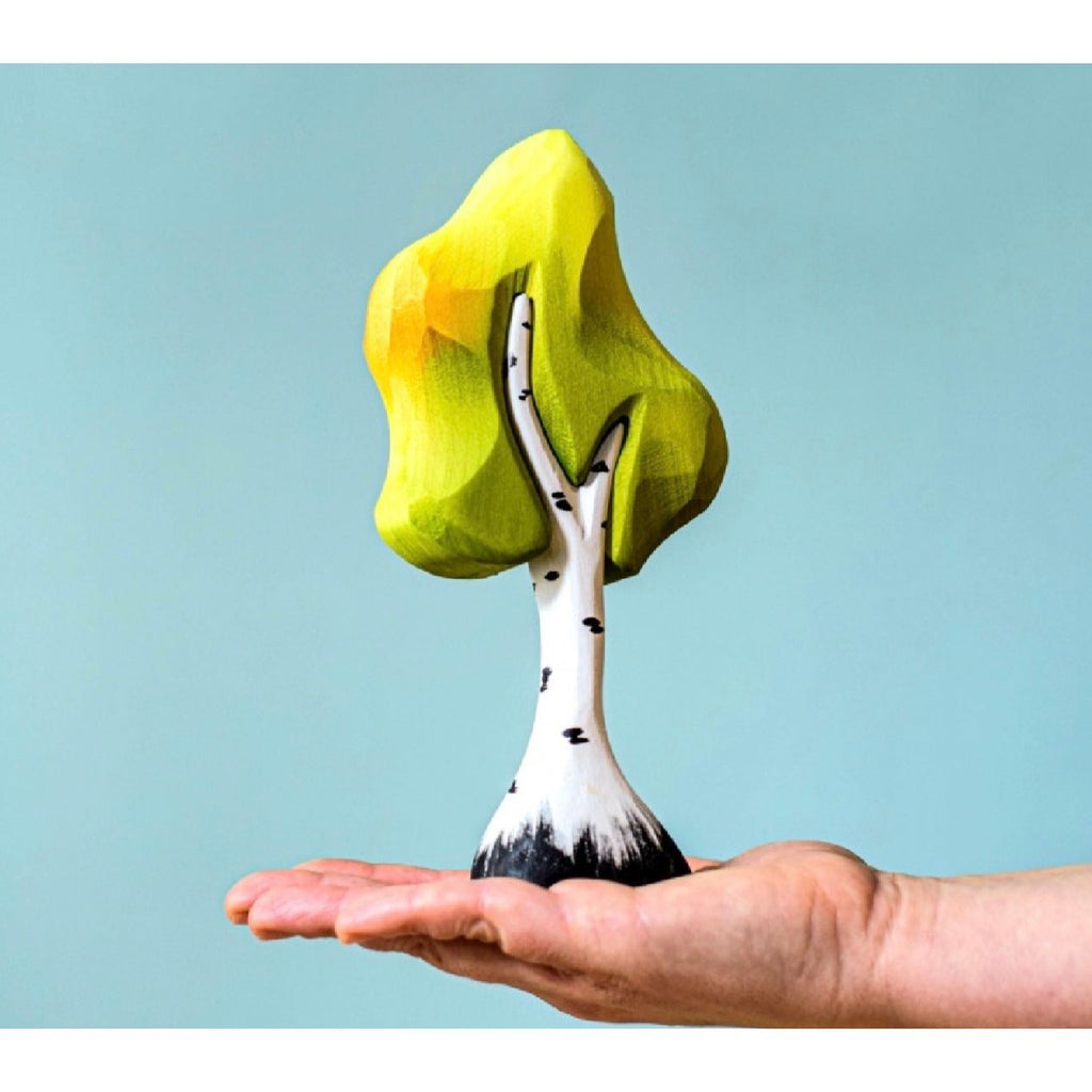 Tree-shaped object with a yellow top and white trunk on a light blue background