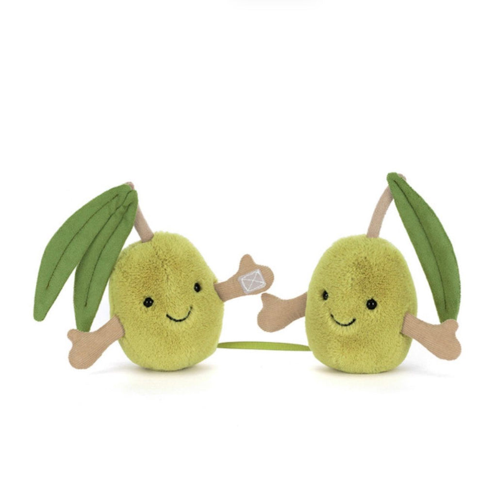 Two plush olives toys with smiling faces on a white background