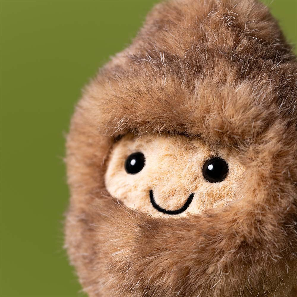 Plush toy sloth with a smiling face on a white background