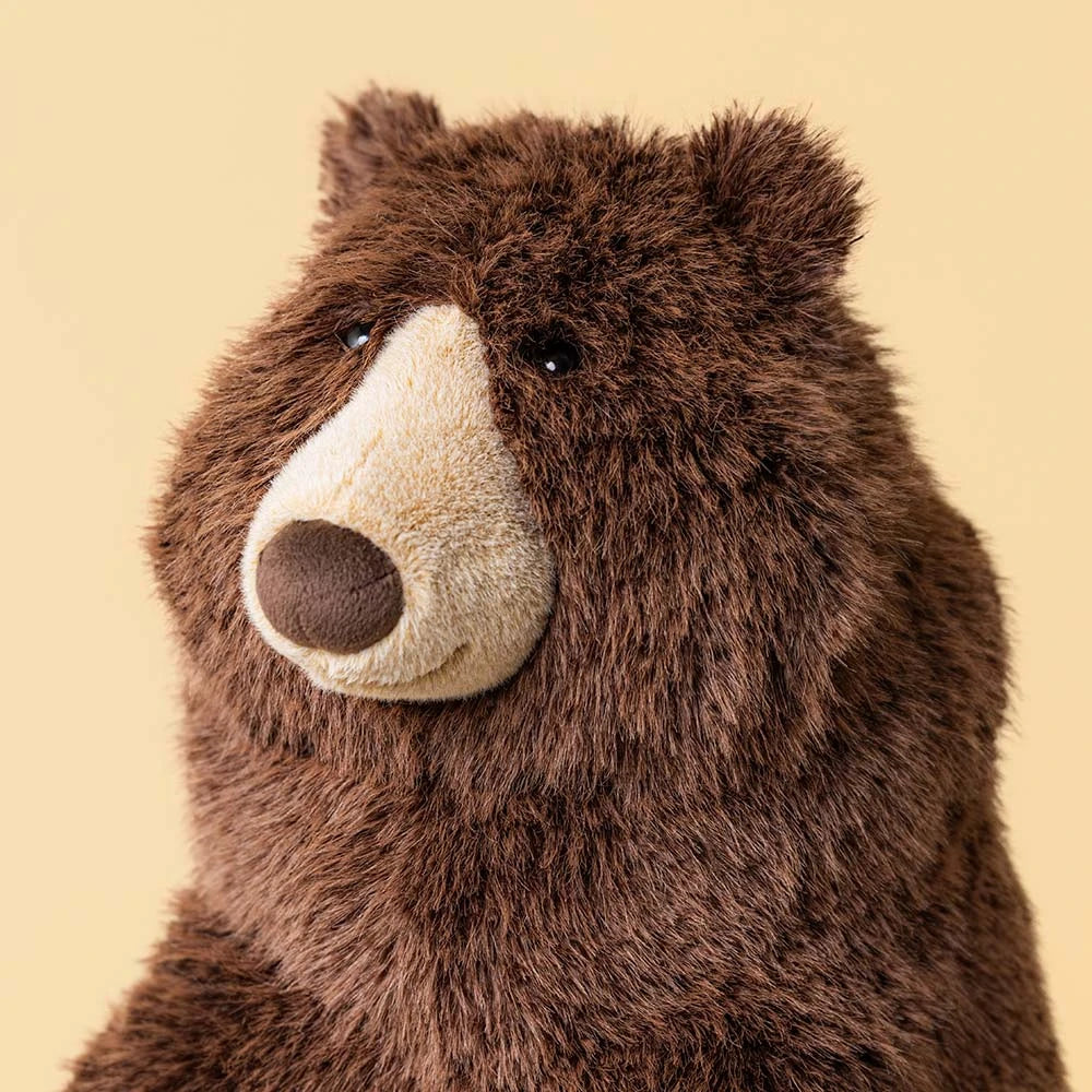 A brown plush stuffed bear toy sitting upright on a clean white background.