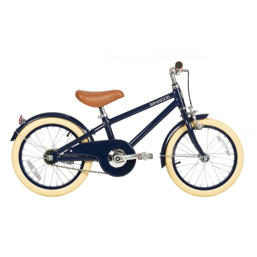 A navy-colored kids' bicycle with a lightweight alloy frame, cream-colored tires, and rosewood pedals. It includes a safety bell, back-pedal brake, hand break, and detachable training wheels.