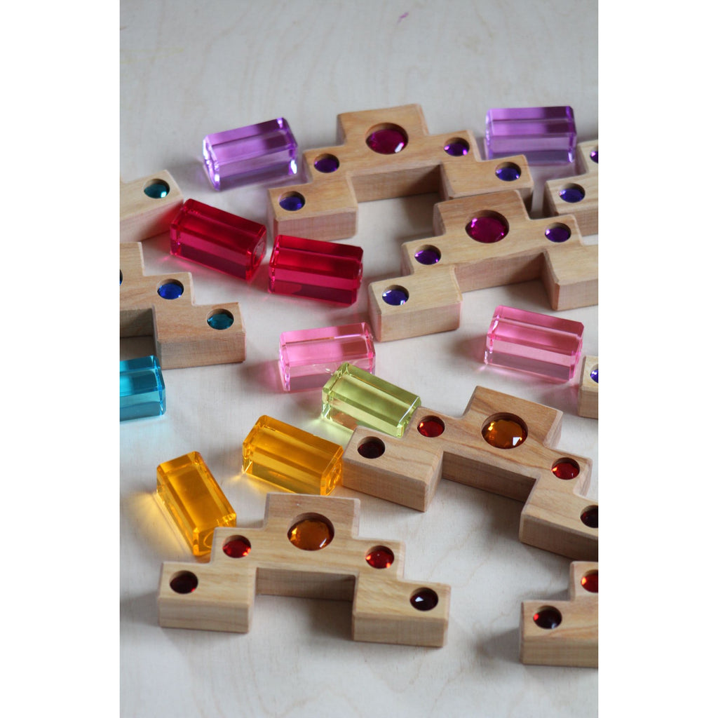 Wooden box with colorful geams on a light surface