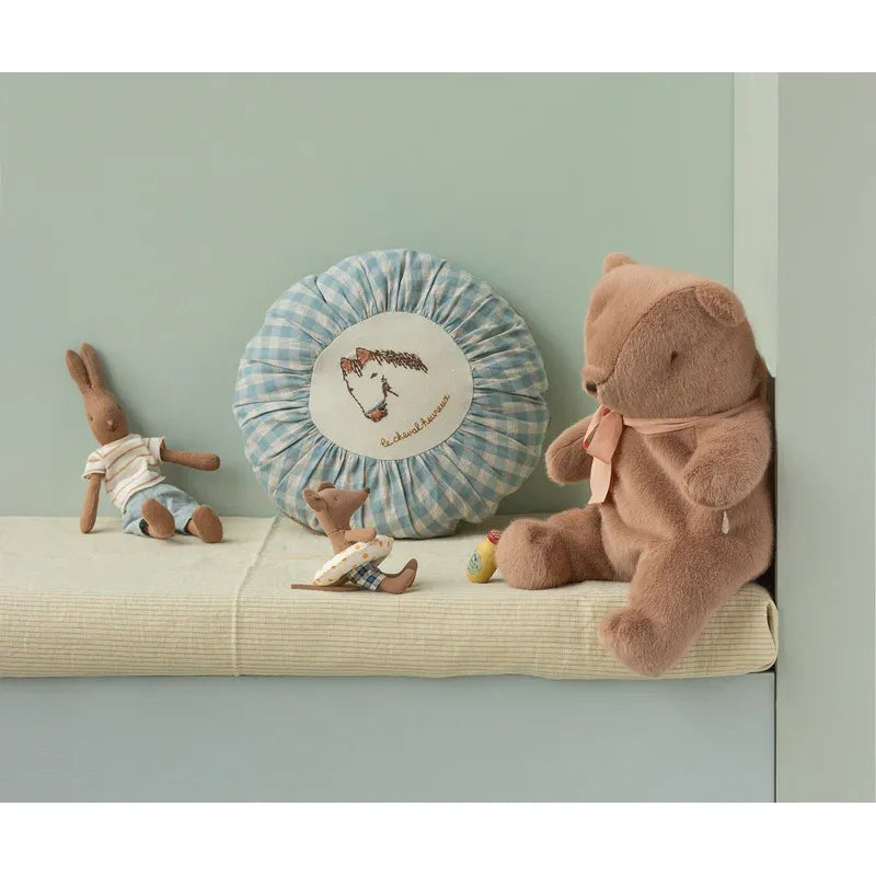 Brown teddy bear with a pink bow on a white background