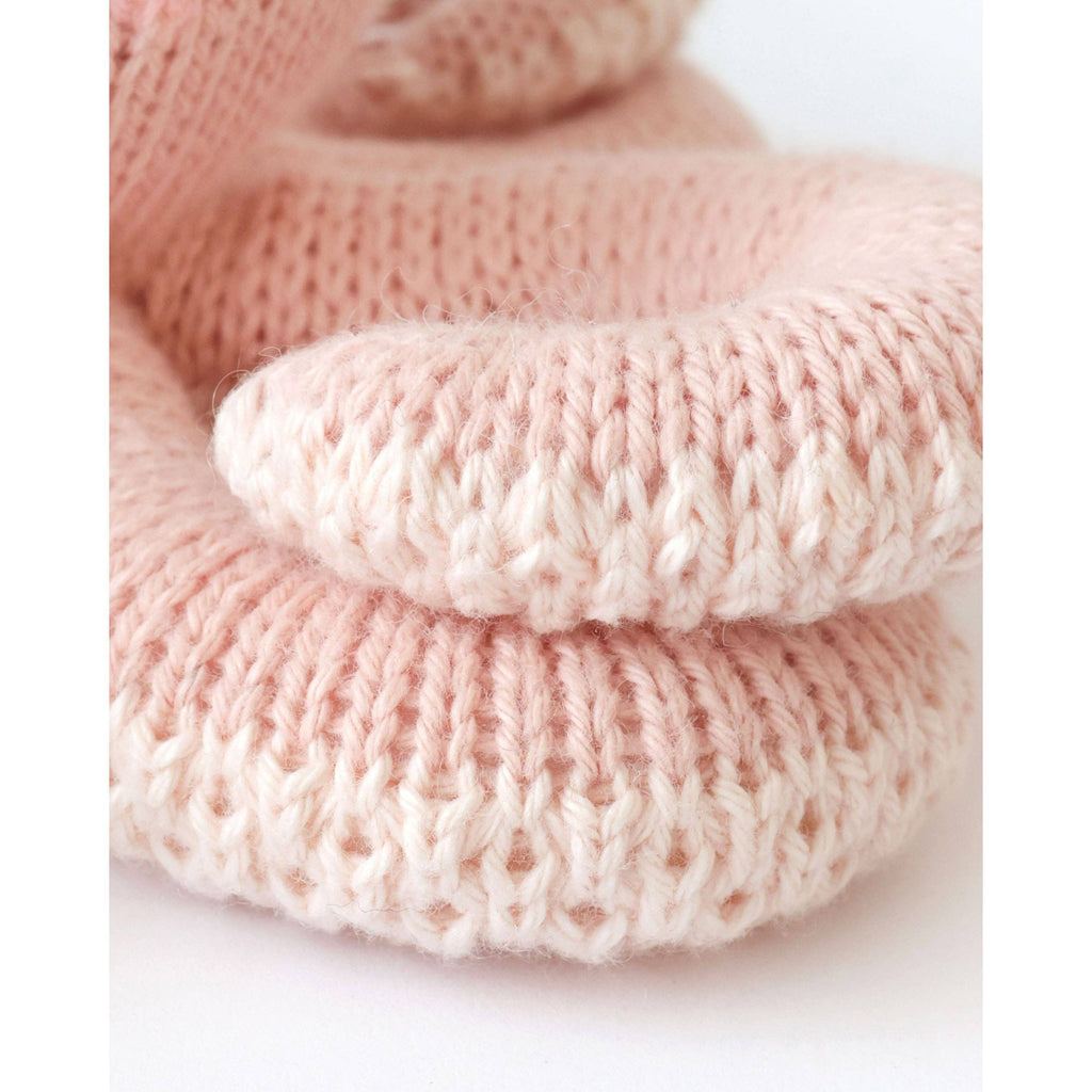 Knitted pink octopus toy with a smiling face 