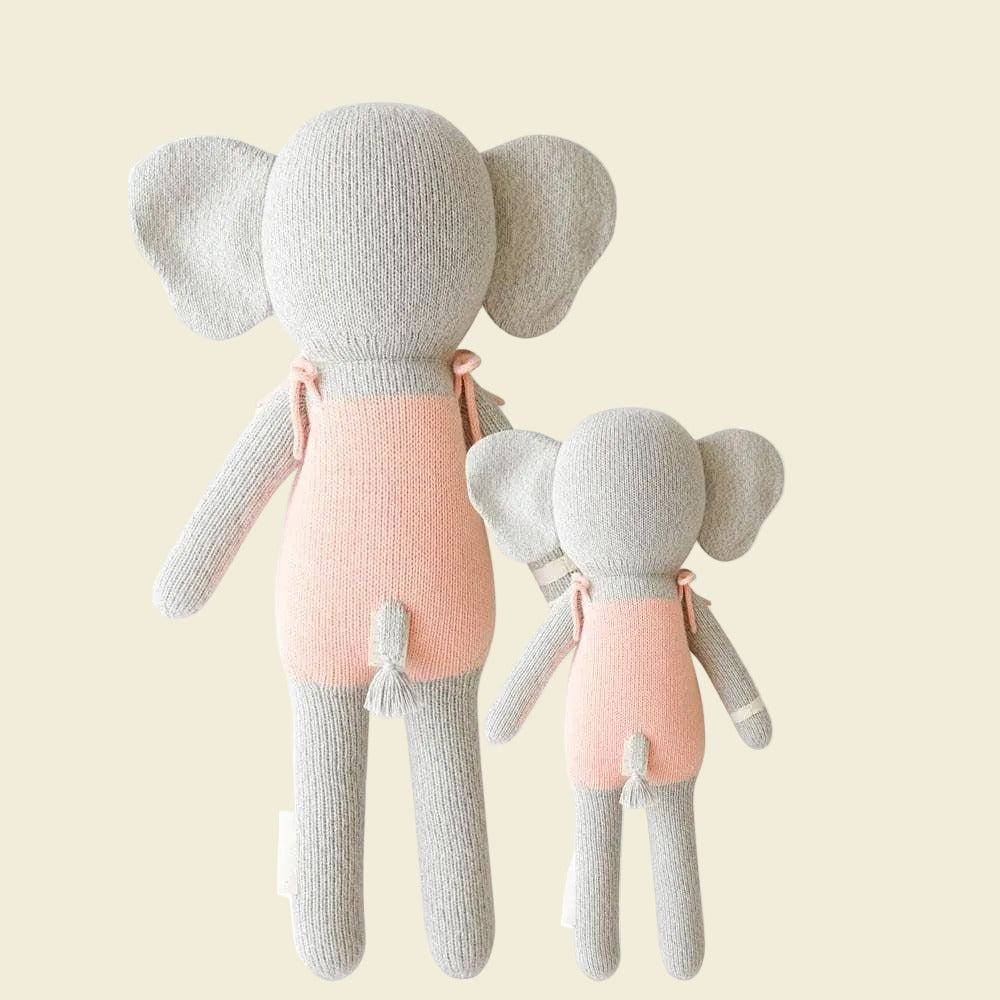Two elephant plush toys, one larger and one smaller, both wearing pink outfits 