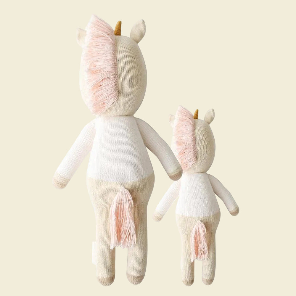 Two unicorn plush toys with rainbow patterns 