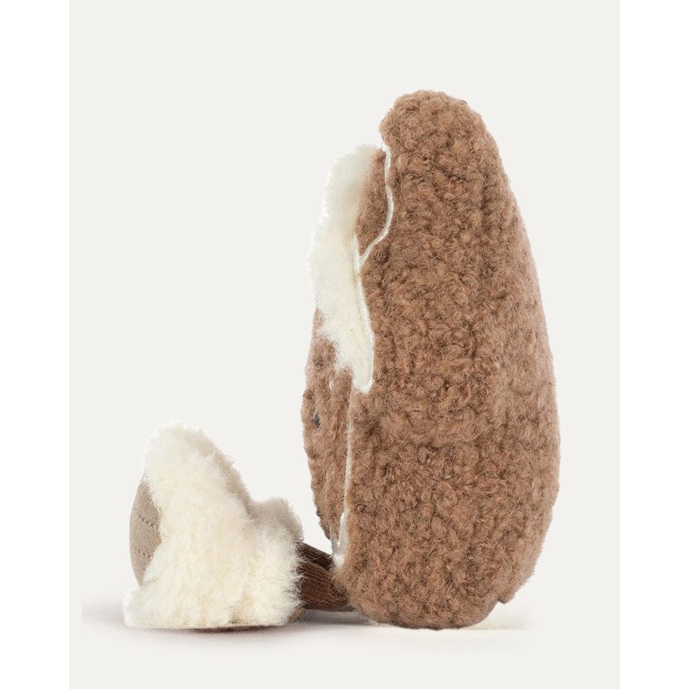 A gingerbread house plush toy with a brown textured body, white icing details, and a smiling face, photographed on a clean off-white background.