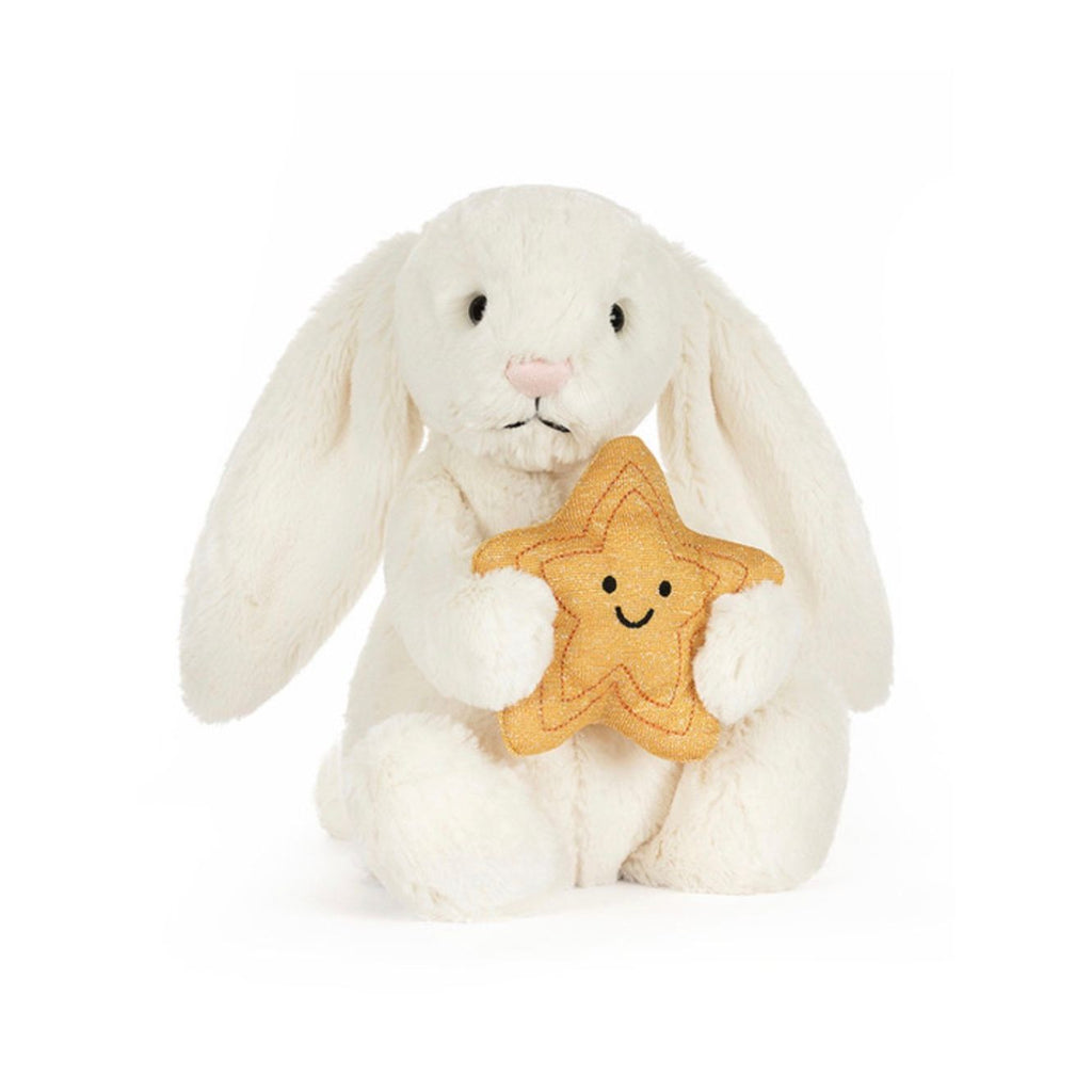 White plush bunny holding a star-shaped cookie with a smiley face on a white background