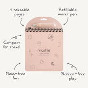 Mushie reusable water color pad, featuring four pages of dreamy fairy tale scenes. A refillable paintbrush allows children to easily “paint” the pages