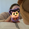 Person holding a small, colorful character light toy with a blurred background