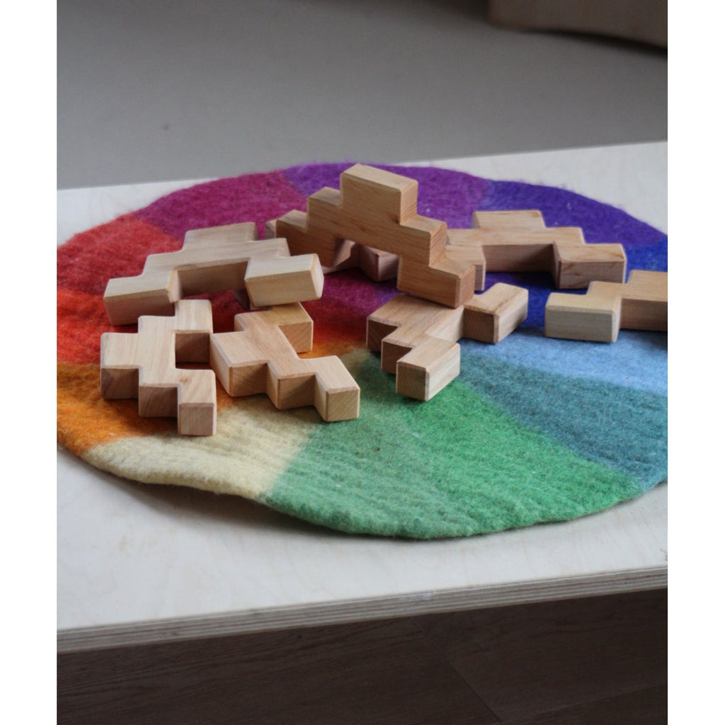 Wooden puzzle pieces on a colorful woven mat