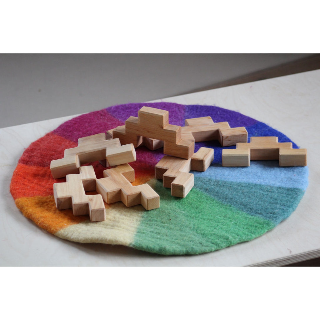 Wooden puzzle pieces on a colorful woven mat
