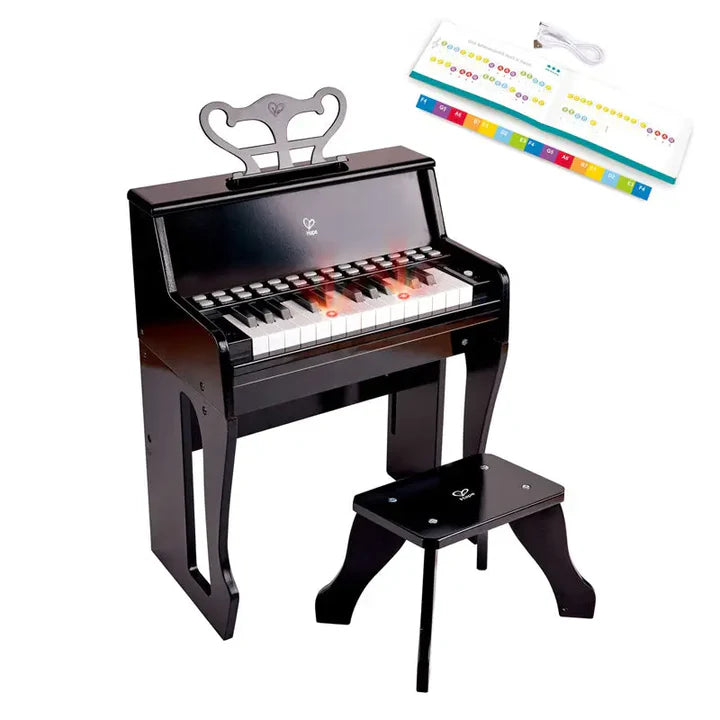 Child playing a black toy piano in a living room setting