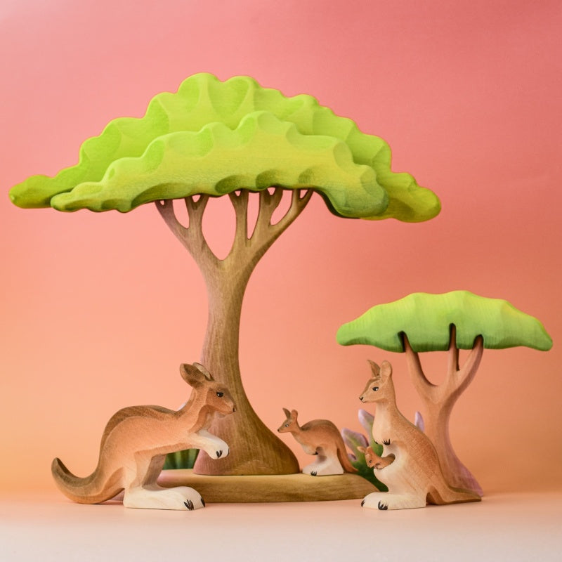 Wooden kangaroo figurine on a wooden surface with a light blue background