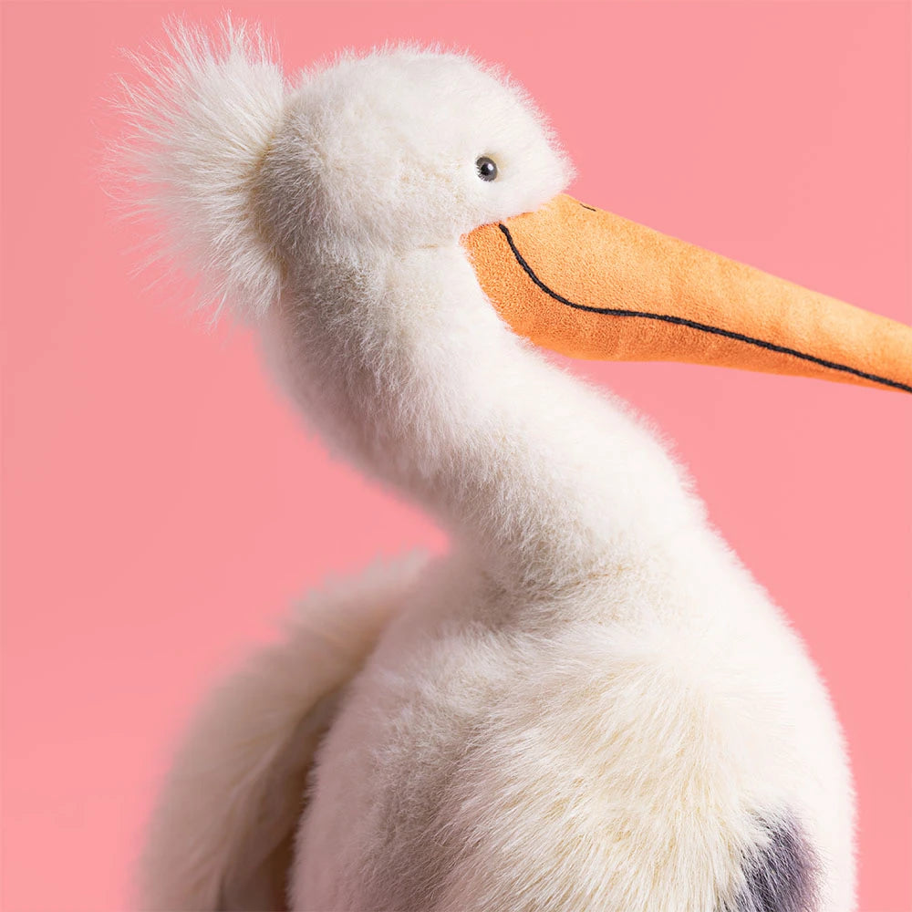 Plush pelican toy with a white body, orange beak, and feet on a white background