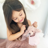 Young girl holding a plush toy with a soft, blurred background