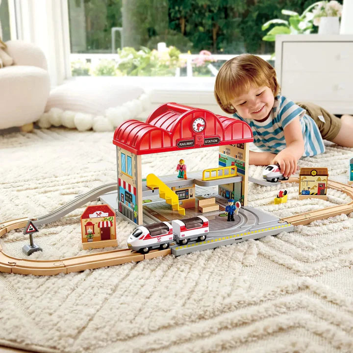 Toy train station set with buildings and track on a white background