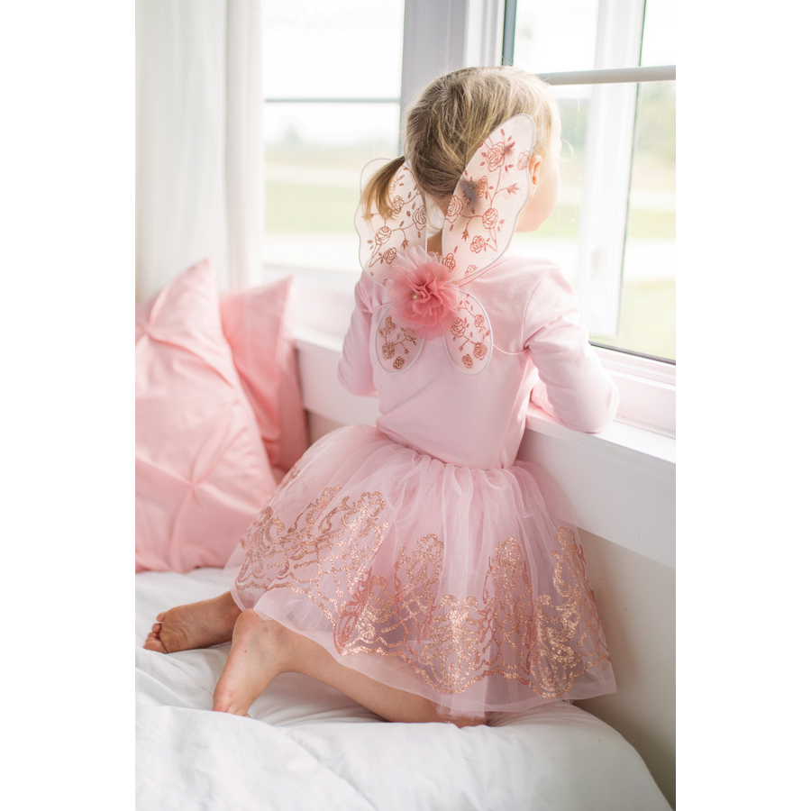 White dress with pink lace overlay and butterfly wings on a mannequin against a white background