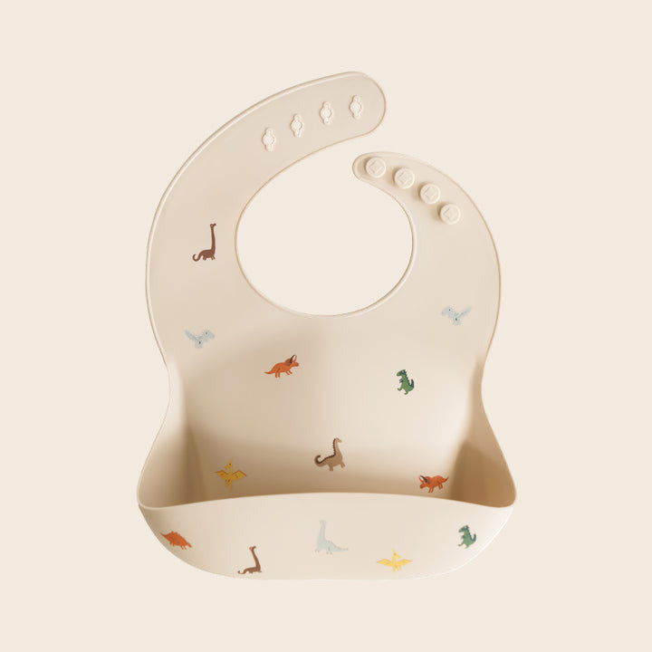 Beige baby silicone bib with dinosaur prints 