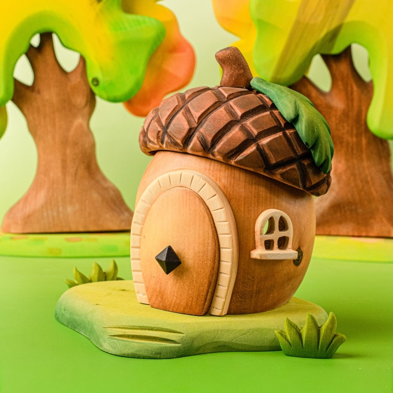 Wooden fairy house with acorn roof on a light blue background