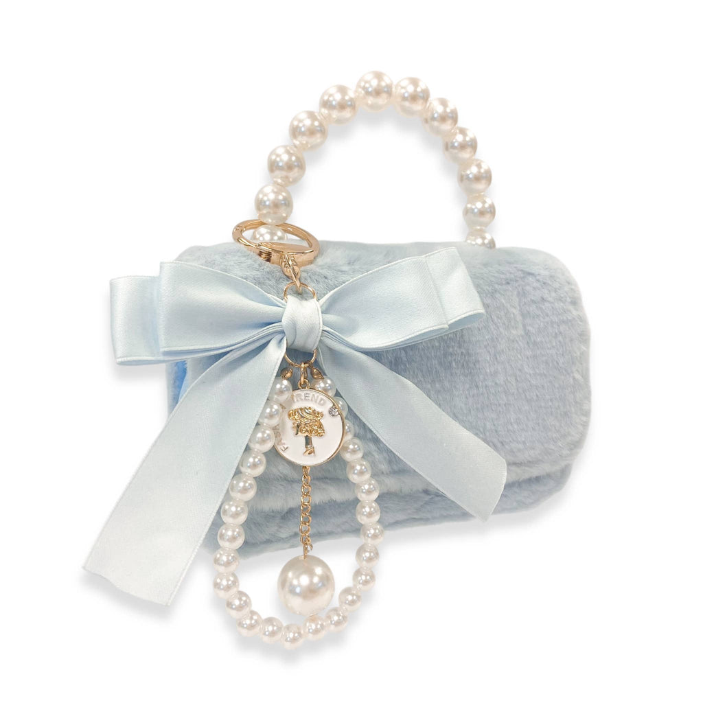 Light blue handbag with pearl handle and decorative bow on a white background
