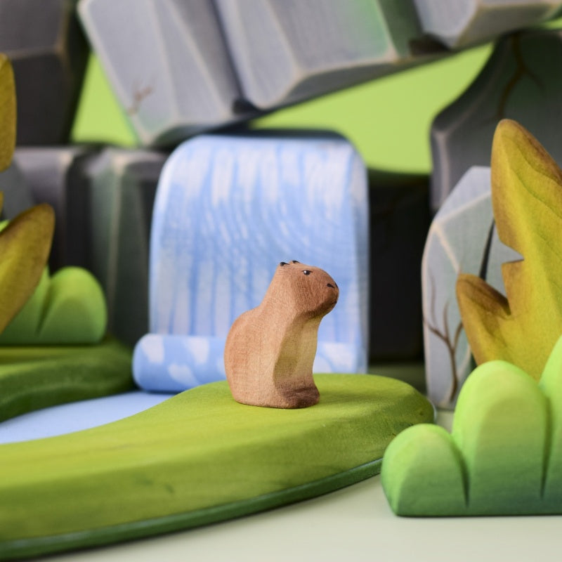 Wooden gopher figurine on a wooden surface with a blurred natural background