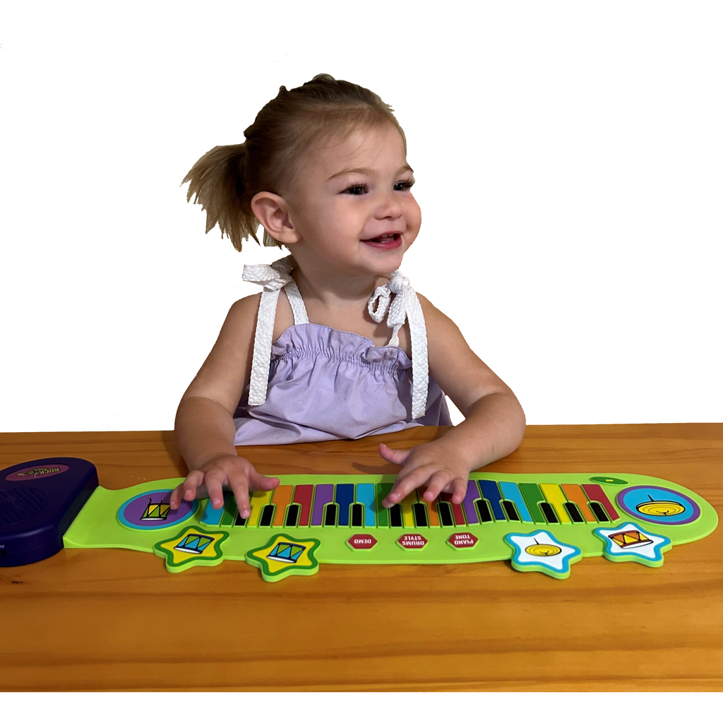 Toy piano and drum set with colorful keys and purple speaker, displayed with packaging.