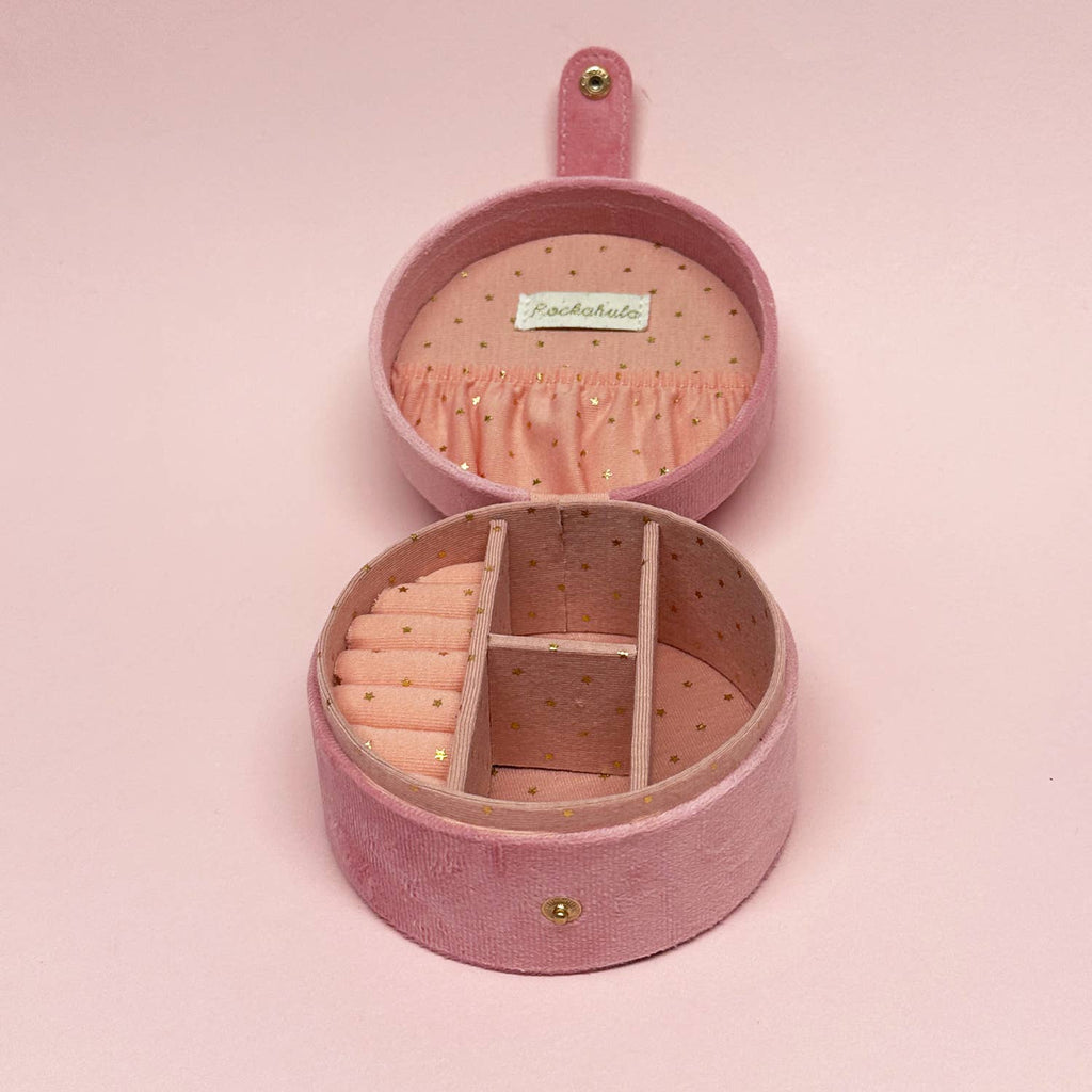 Pink round jewelry box with a bow on a pink background