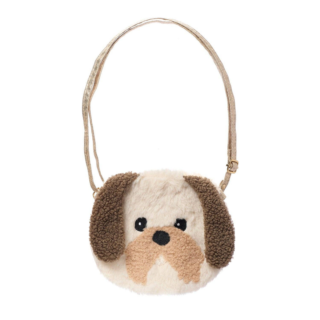 Child holding a plush dog bag on a wooden surface