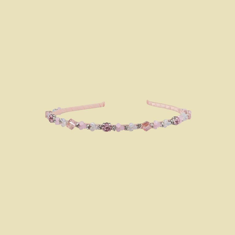 Delicate headband with floral and beaded details on a light pink background
