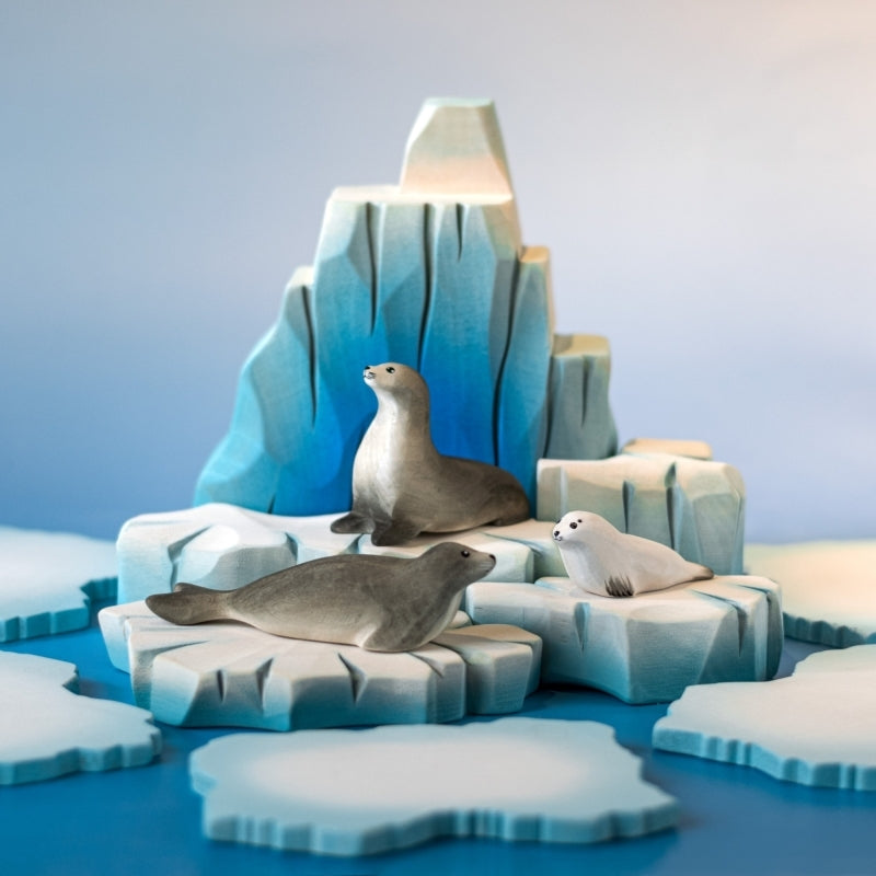 Iceberg sculpture with gradient blue and white colors on a wooden surface and light blue background