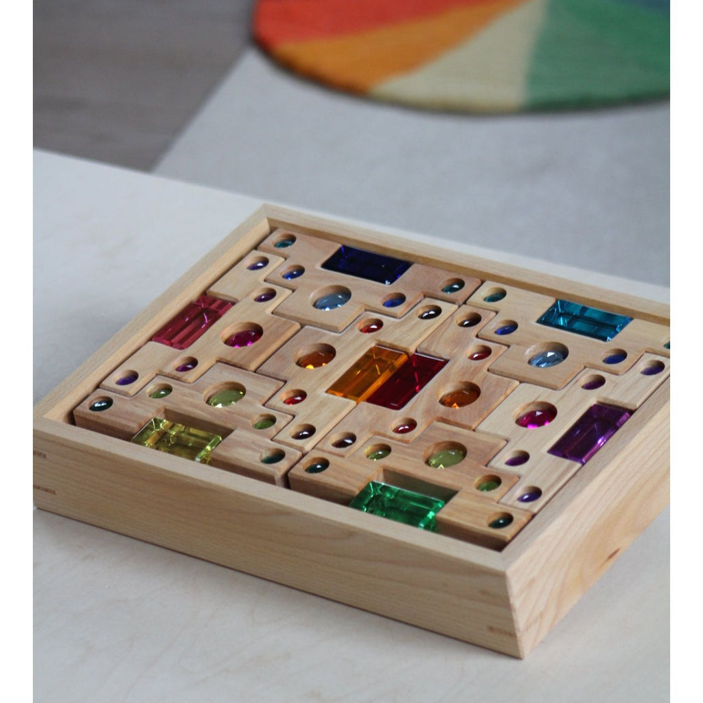 Wooden box with colorful geams on a light surface