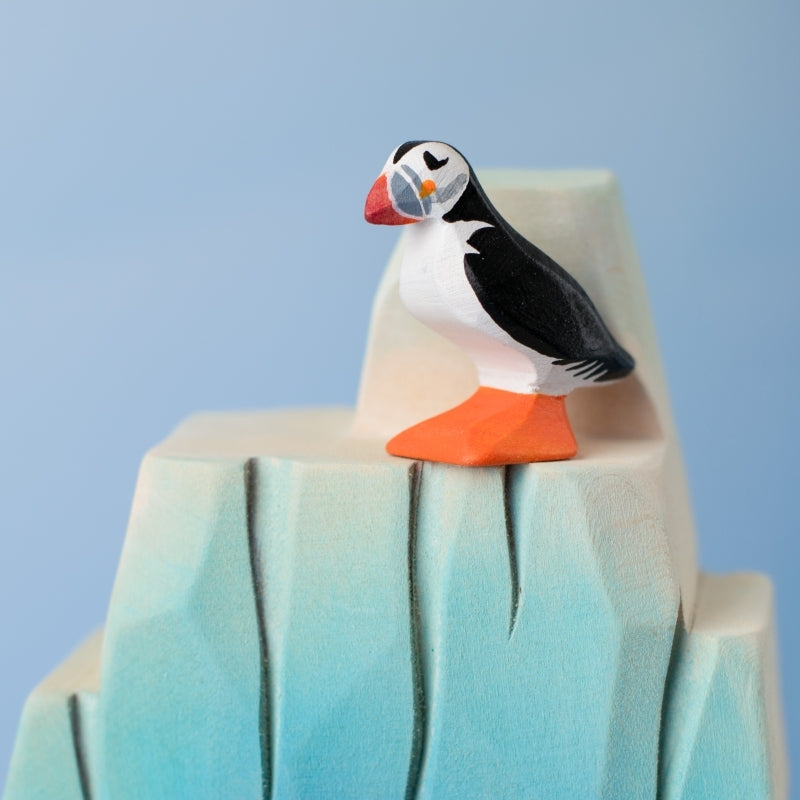 Model of a puffin on a sandy surface with a blurred green background
