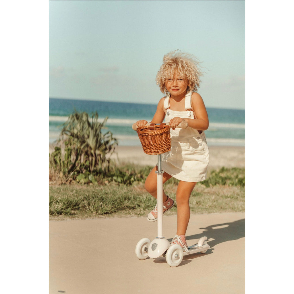 A classic, white Banwood three-wheeled scooter with a wooden footboard and adjustable T-bar handle.